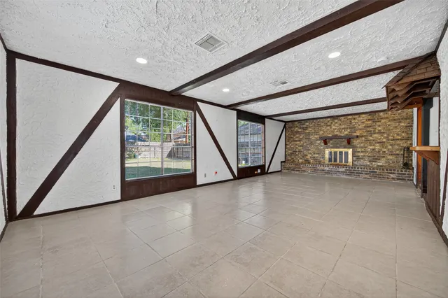 a view of an empty room with a fireplace and a large window