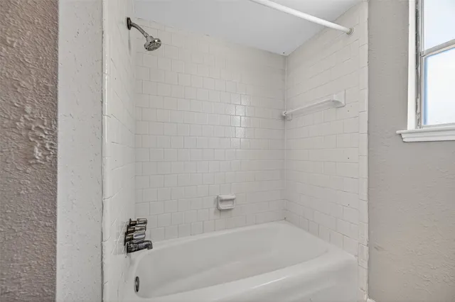 an empty room with a ceiling fan and window