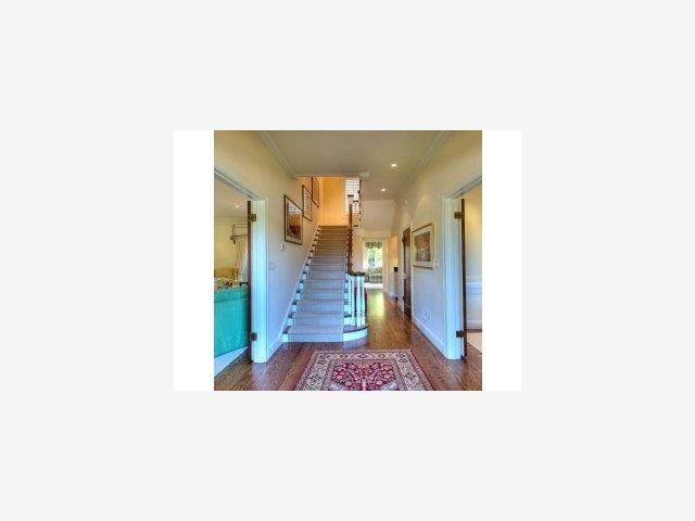 238 Harvard Road San Mateo, CA 94402 - Photo 2 of 9 a hallway with a large mirror and a sink