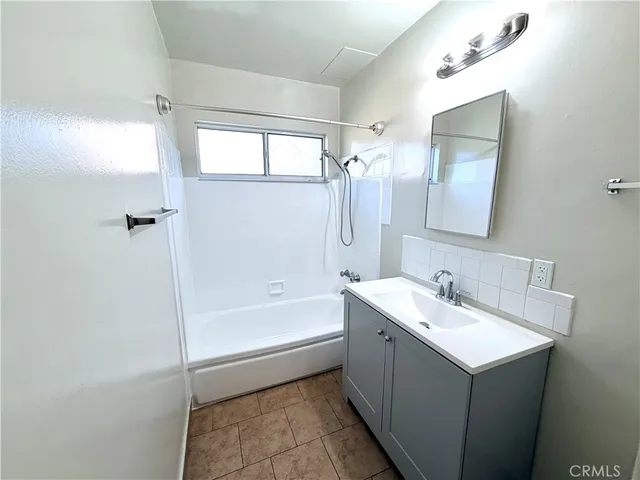 a bathroom with a tub sink and mirror