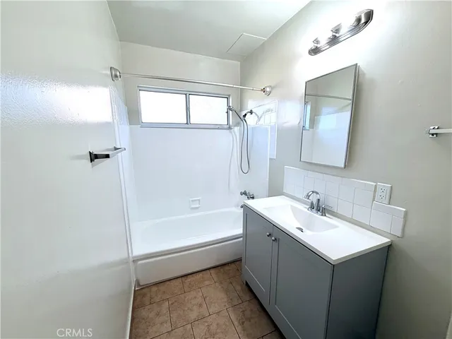 a bathroom with a tub sink and mirror