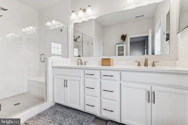 a bathroom with a double vanity sink mirror and shower