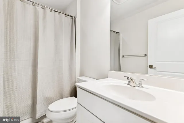 a bathroom with a sink a toilet and shower curtain