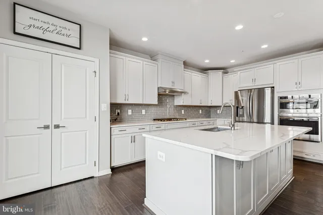 a kitchen with white cabinets and white appliances