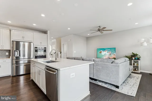 a view of kitchen with sink and refrigerator