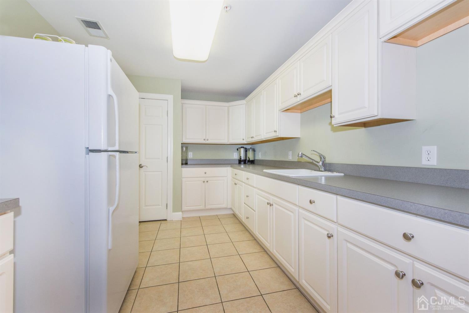 181 Liddle Avenue Edison, NJ 08837 - Photo 4 of 6 a kitchen with white cabinets a sink a stove and a refrigerator