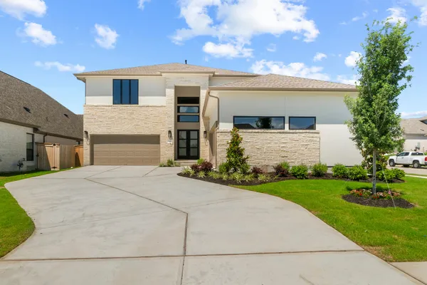 a front view of a house with a yard and garage