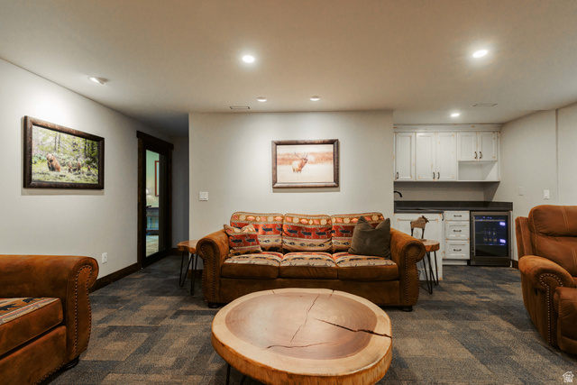 1667 West Tollgate Cyn Road Coalville, UT 84017 - Photo 46 of 61 Recreation room featuring recessed lighting, patterned carpet flooring, a dark wood-framed doorway, and a built-in wet bar with white cabinetry, dark countertops, and a beverage refrigerator
