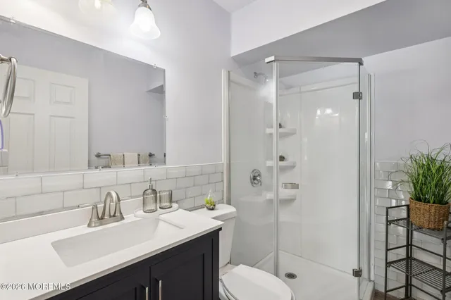 a bathroom with a sink toilet vanity and shower