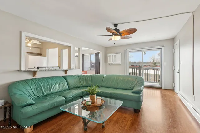 a living room with furniture a ceiling fan and a window