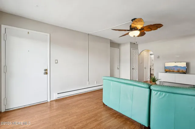 a view of a room with wooden floor and ceiling fan