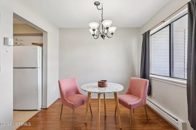a dining room with wooden floor a glass table and chairs