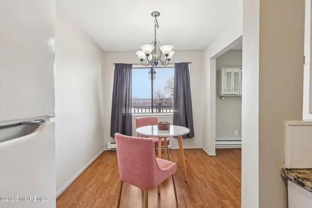 a dining room with furniture a chandelier and wooden floor