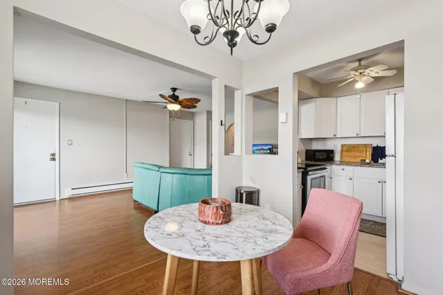 a kitchen with stainless steel appliances granite countertop a table chairs and a refrigerator