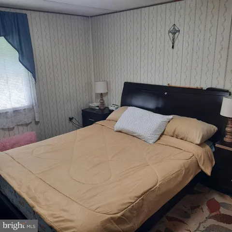 a large bed sitting in a bedroom next to a window