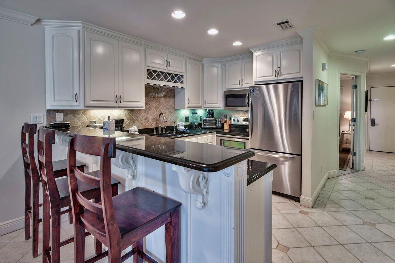214 Blue Mountain Road, Unit 111 Santa Rosa Beach, FL 32459 - Photo 8 of 13 a kitchen with stainless steel appliances granite countertop a table chairs refrigerator and microwave