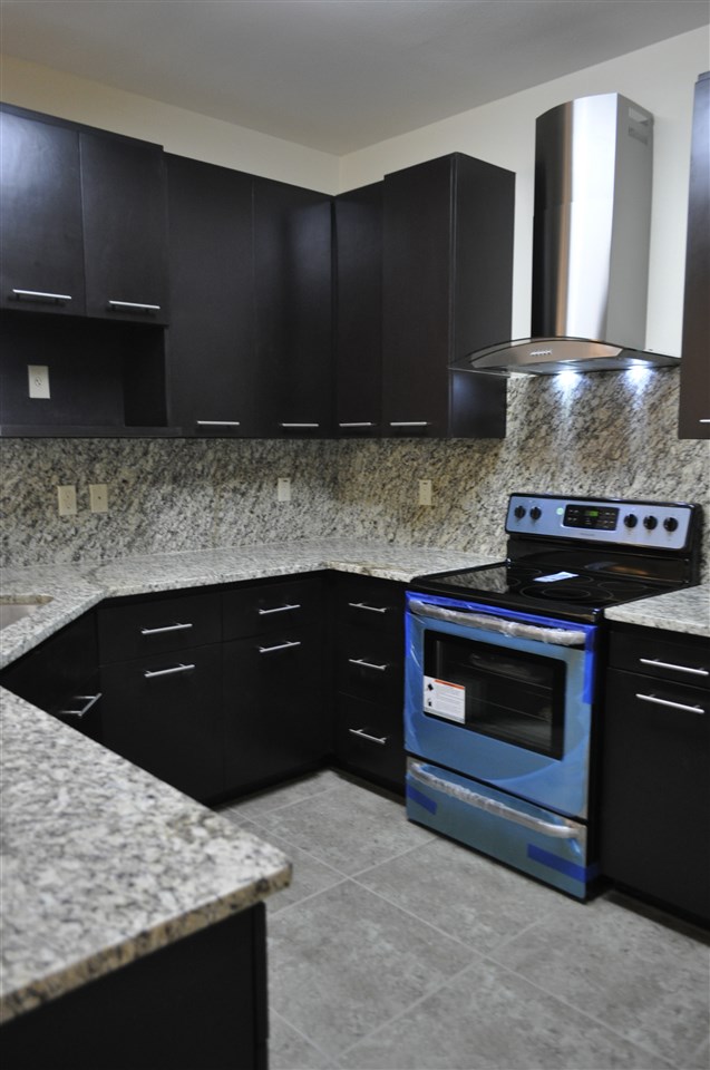 8216 Casa Verde Road, Unit E158 Laredo, TX 78041 - Photo 5 of 20 a kitchen with granite countertop stainless steel appliances and cabinets