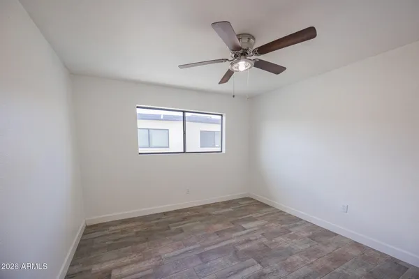 a view of a big room with wooden floor closet and windows
