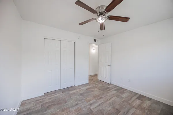en empty room with fan and a ceiling fan