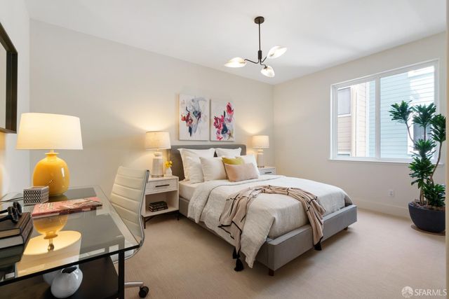 a bedroom with a bed chandelier and window