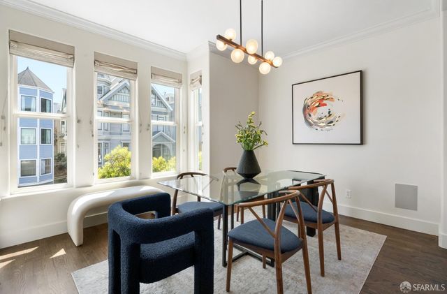 a view of a dining room with furniture large windows and wooden floor