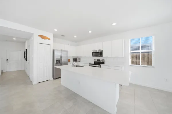 a view of a kitchen with furniture and refrigerator