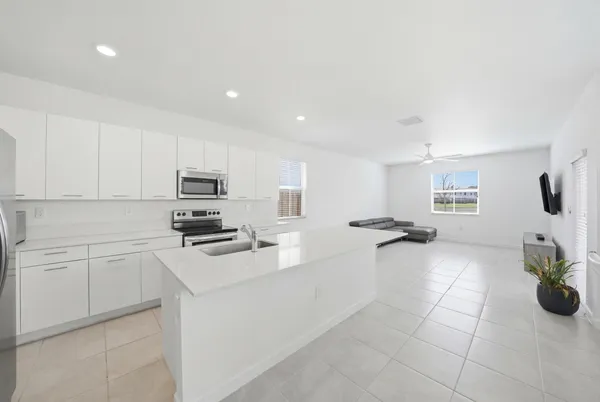 a kitchen with stainless steel appliances a sink a stove top oven a counter space and cabinets