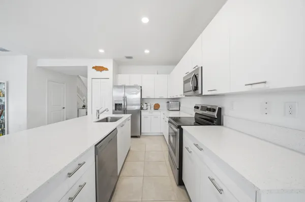 a kitchen with white cabinets and white appliances