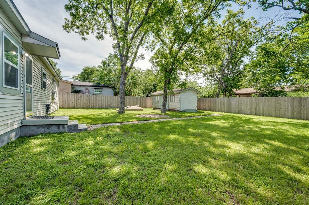 2316 Cunningham Street Irving, TX 75062 - Photo 21 of 22 Spacious backyard featuring a manicured lawn, established trees, and a privacy fence