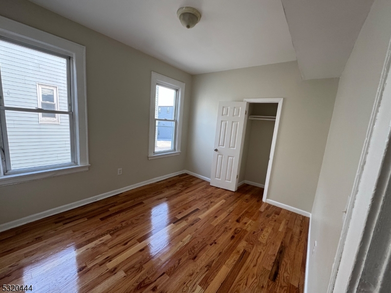 285 Wainwright Street Newark, NJ 07112 - Photo 14 of 27 a view of an empty room with wooden floor and a window