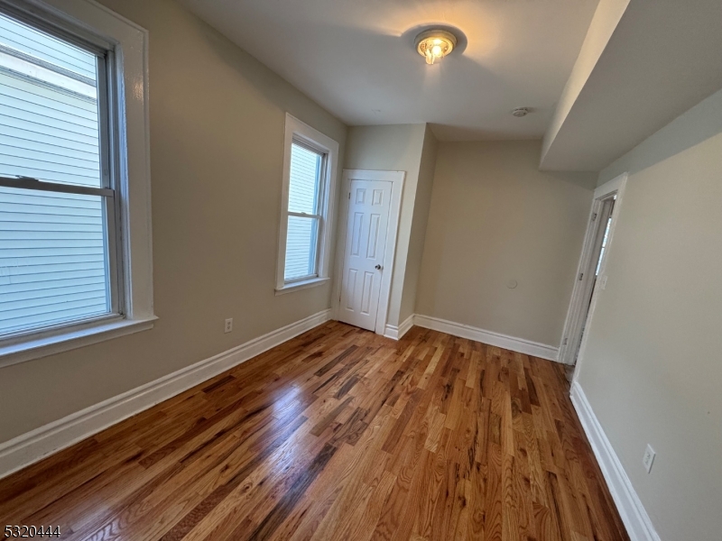 285 Wainwright Street Newark, NJ 07112 - Photo 16 of 27 a view of an empty room with wooden floor and a window
