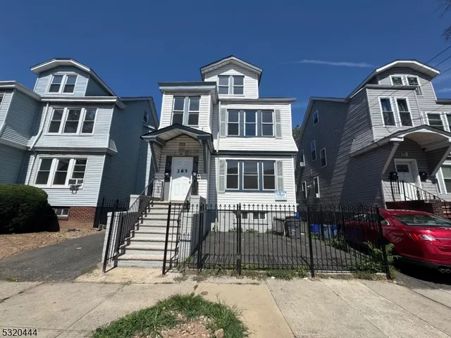 a front view of a residential apartment building with a yard