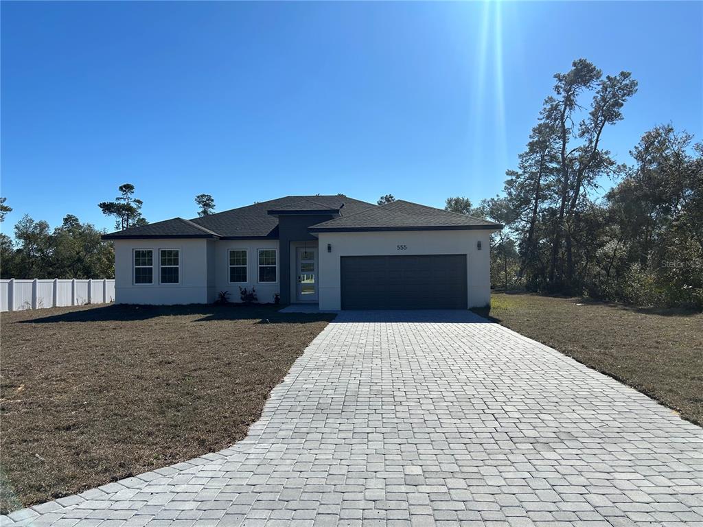 a front view of a house with a yard and garage