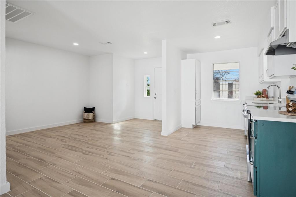 1809 Dunning Street Irving, TX 75061 - Photo 14 of 35 a view of an empty room with wooden floor and a kitchen