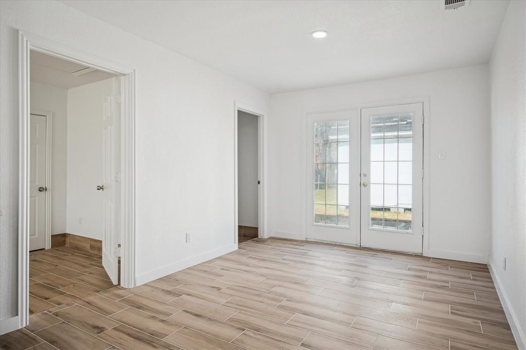 1809 Dunning Street Irving, TX 75061 - Photo 17 of 35 a view of an empty room with window and wooden floor