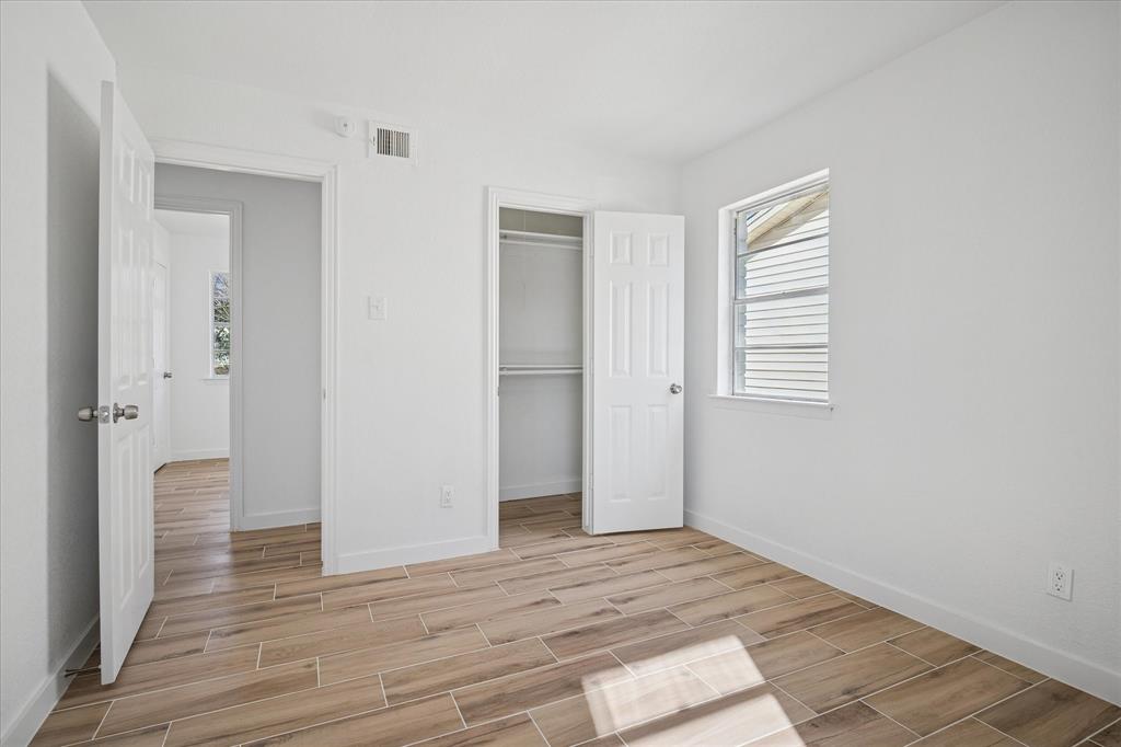 1809 Dunning Street Irving, TX 75061 - Photo 21 of 35 a view of an empty room with wooden floor and a window