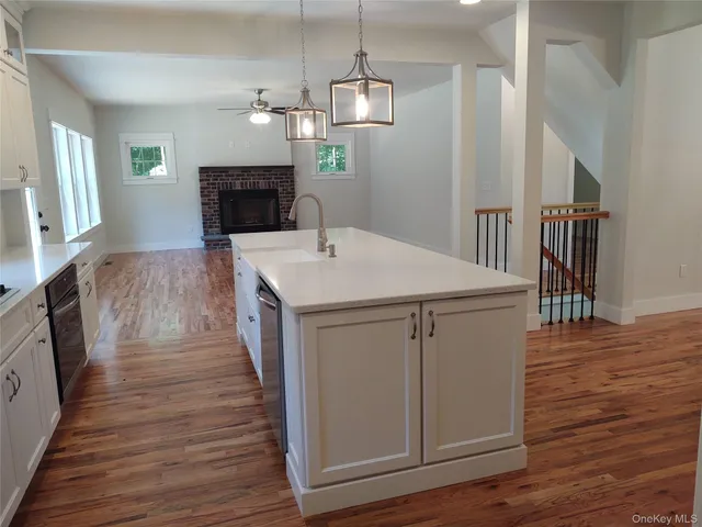 a kitchen with kitchen island white cabinets appliances and wooden floor