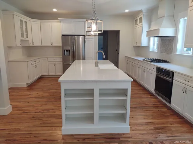 a view of empty room with wooden floor fan and window