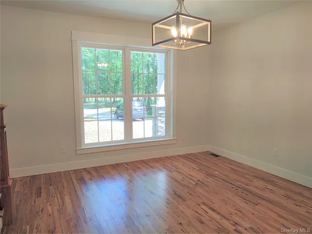 a view of a room with wooden floor and window