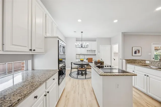 a kitchen with granite countertop a sink stove and cabinets