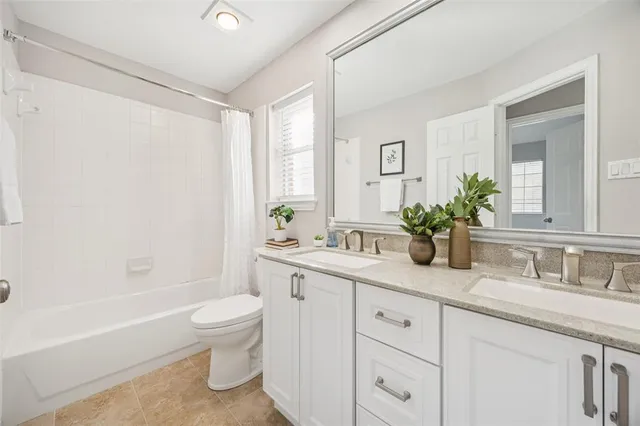 a bathroom with a granite countertop sink a toilet and a bathtub