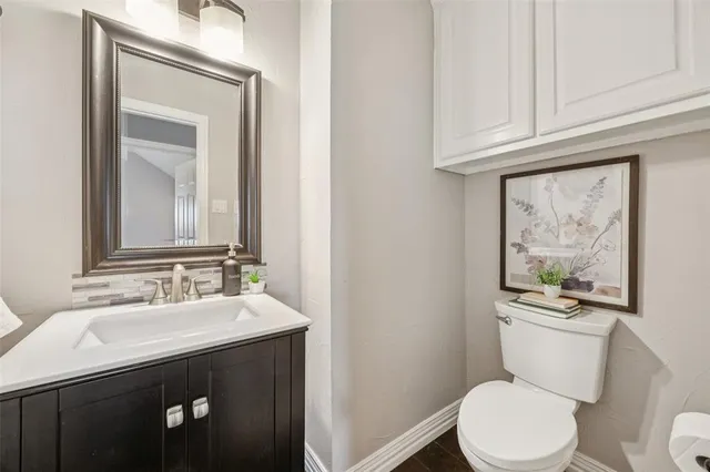 a bathroom with a toilet a sink and mirror