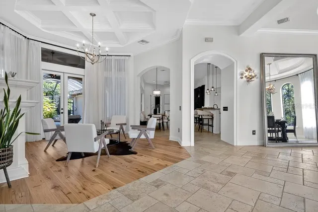 a living room with furniture a fireplace and a chandelier