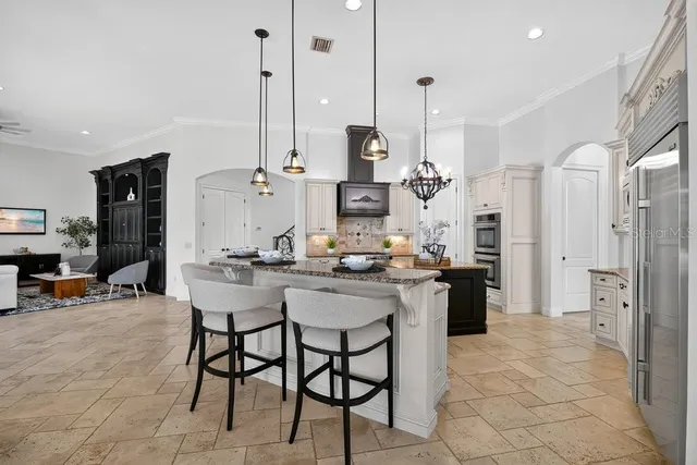 a kitchen with kitchen island granite countertop a sink appliances and cabinets