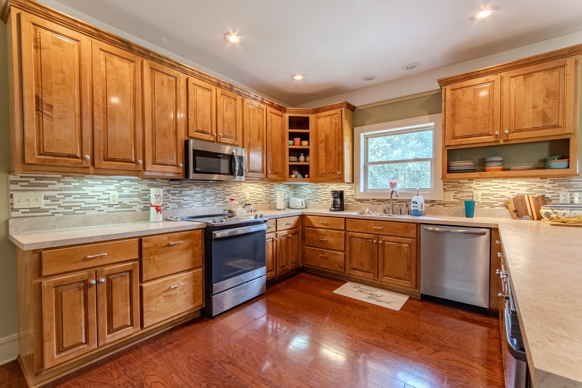 2690 Fellowship Road Sardis, TN 38371 - Photo 7 of 40 a kitchen with stainless steel appliances granite countertop wooden cabinets a stove a sink and dishwasher with wooden floor