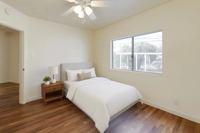 a bedroom with a bed and wooden floor