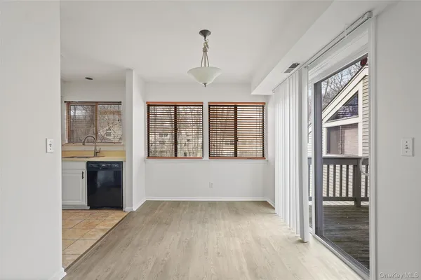 a view of a hallway with wooden floor and a living room