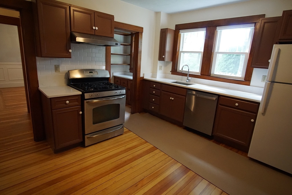 754 Massachusetts Avenue, Unit 1 Lexington, MA 02421 - Photo 12 of 17 a kitchen with stainless steel appliances granite countertop a stove a sink and a refrigerator