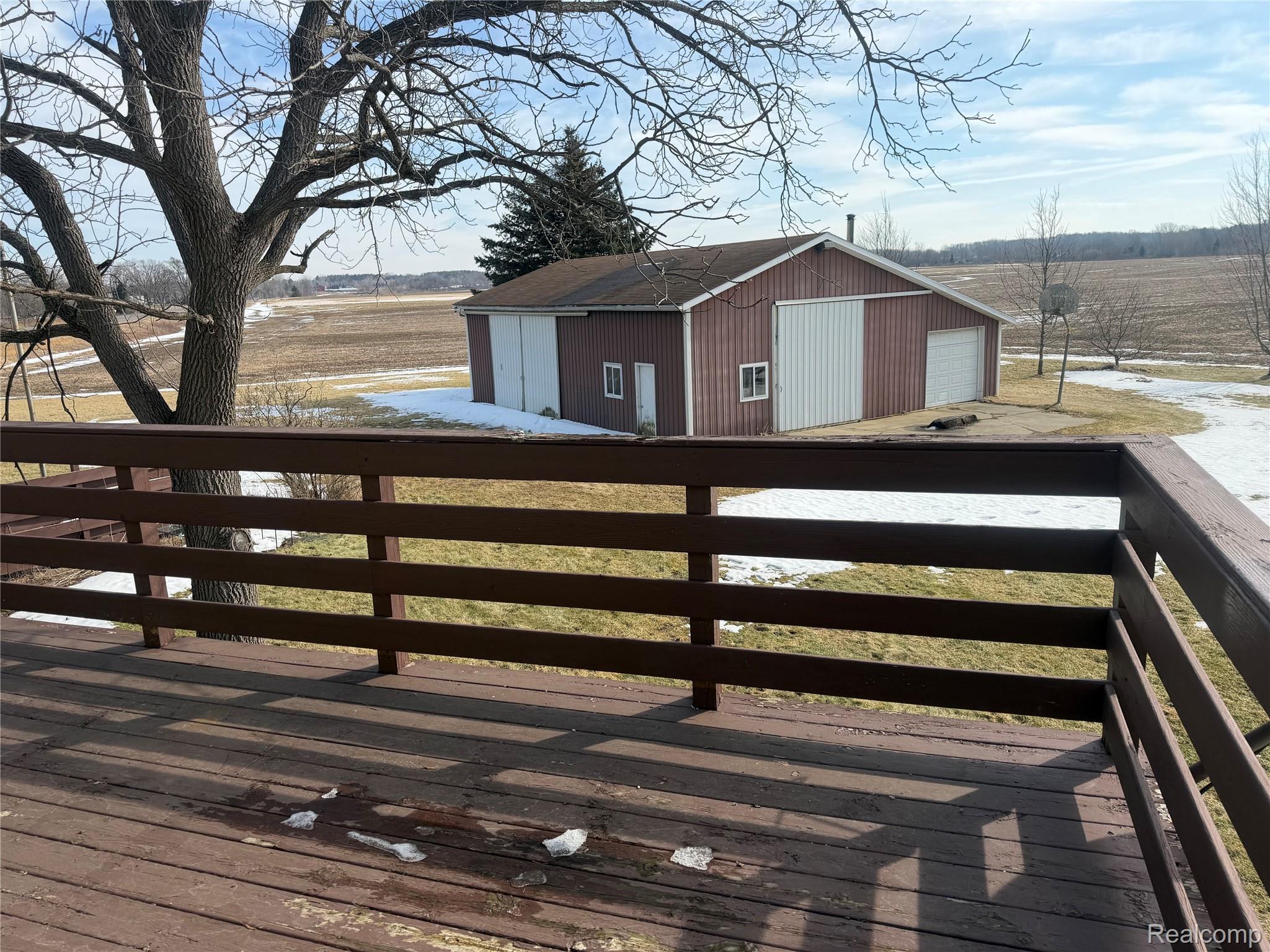 5749 Leix Road Mayville, MI 48744 - Photo 43 of 44 Wooden terrace featuring an outbuilding, a detached garage, and a view of countryside