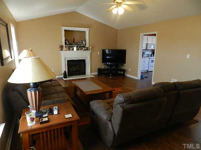 174 Roping Horn Way Willow Spring, NC 27592 - Photo 3 of 15 a living room with furniture a flat screen tv and a fireplace
